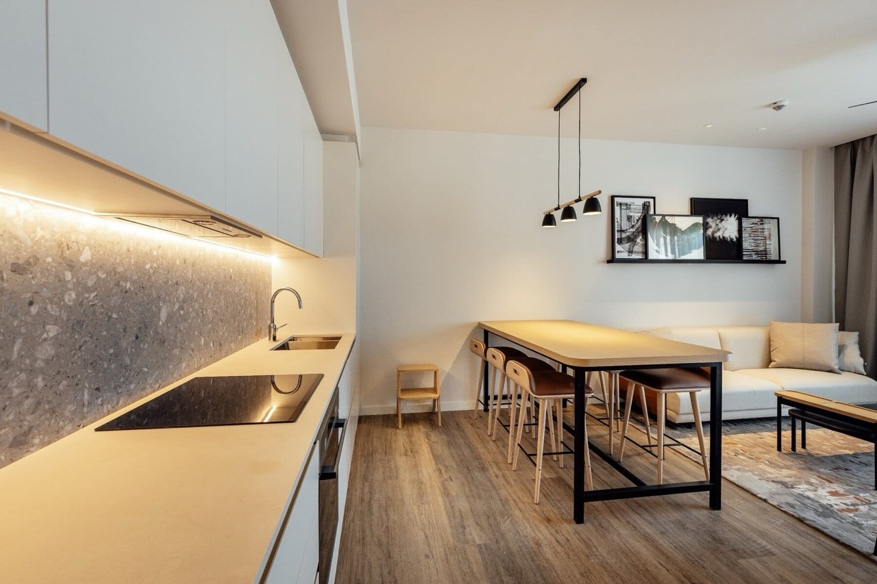 Modern kitchen-living room in an apartment in Porto Montenegro, Tivat, Montenegro: white furniture, a bar counter, and decor.