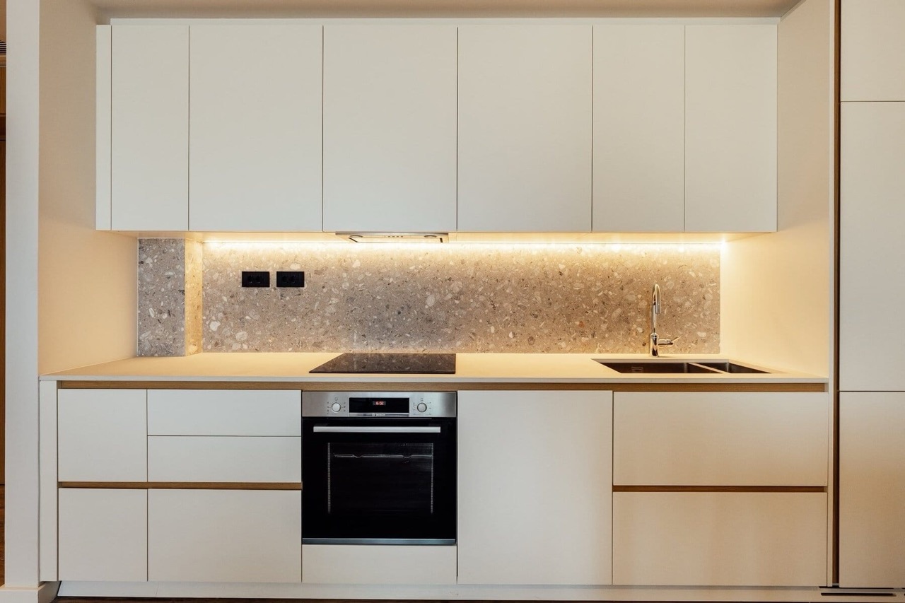 Modern white kitchen with a terrazzo backsplash in an apartment in Porto Montenegro, Tivat, Montenegro.