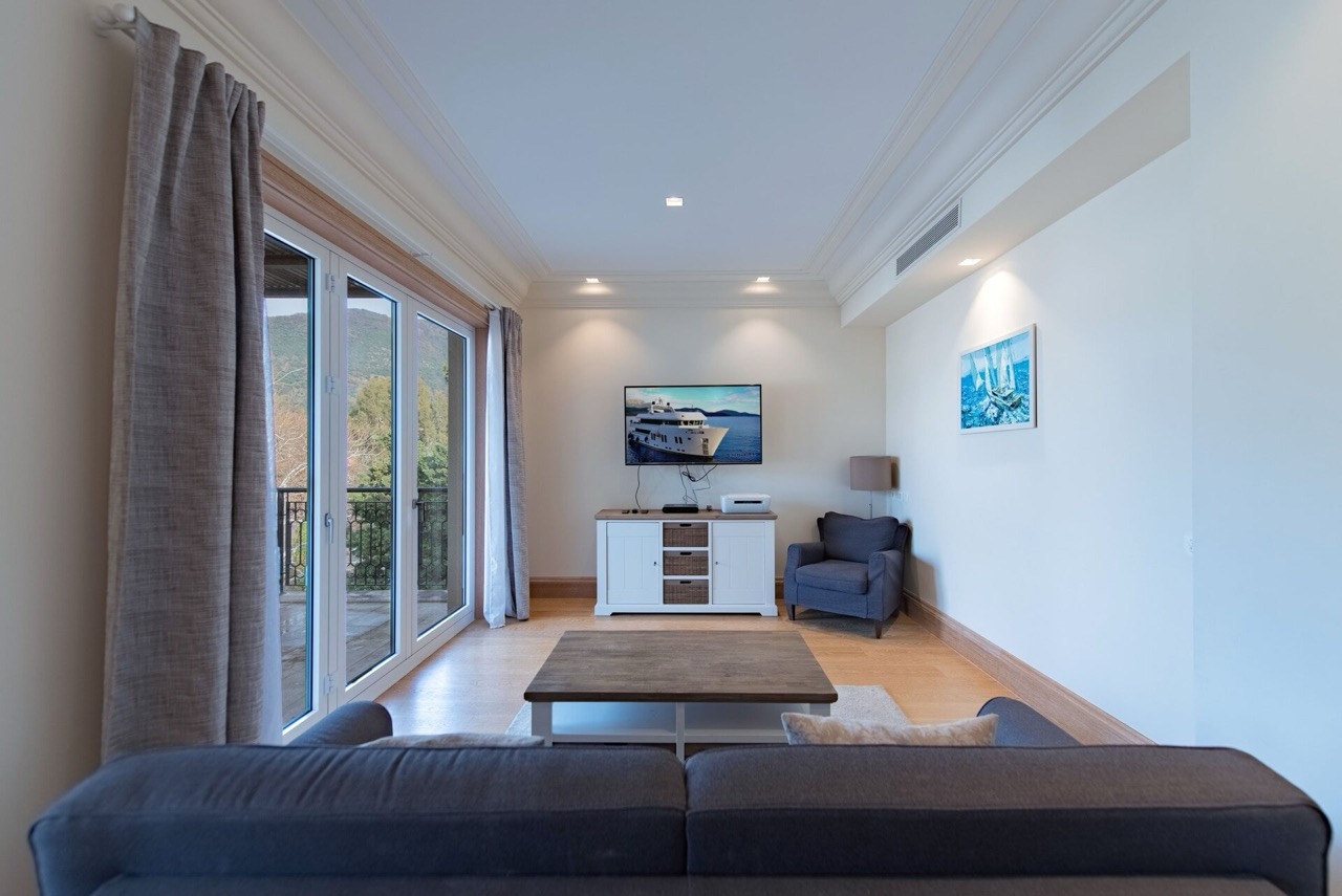 Living room in an apartment in Porto Montenegro, Tivat, Montenegro: modern interior, panoramic windows, and mountain views.