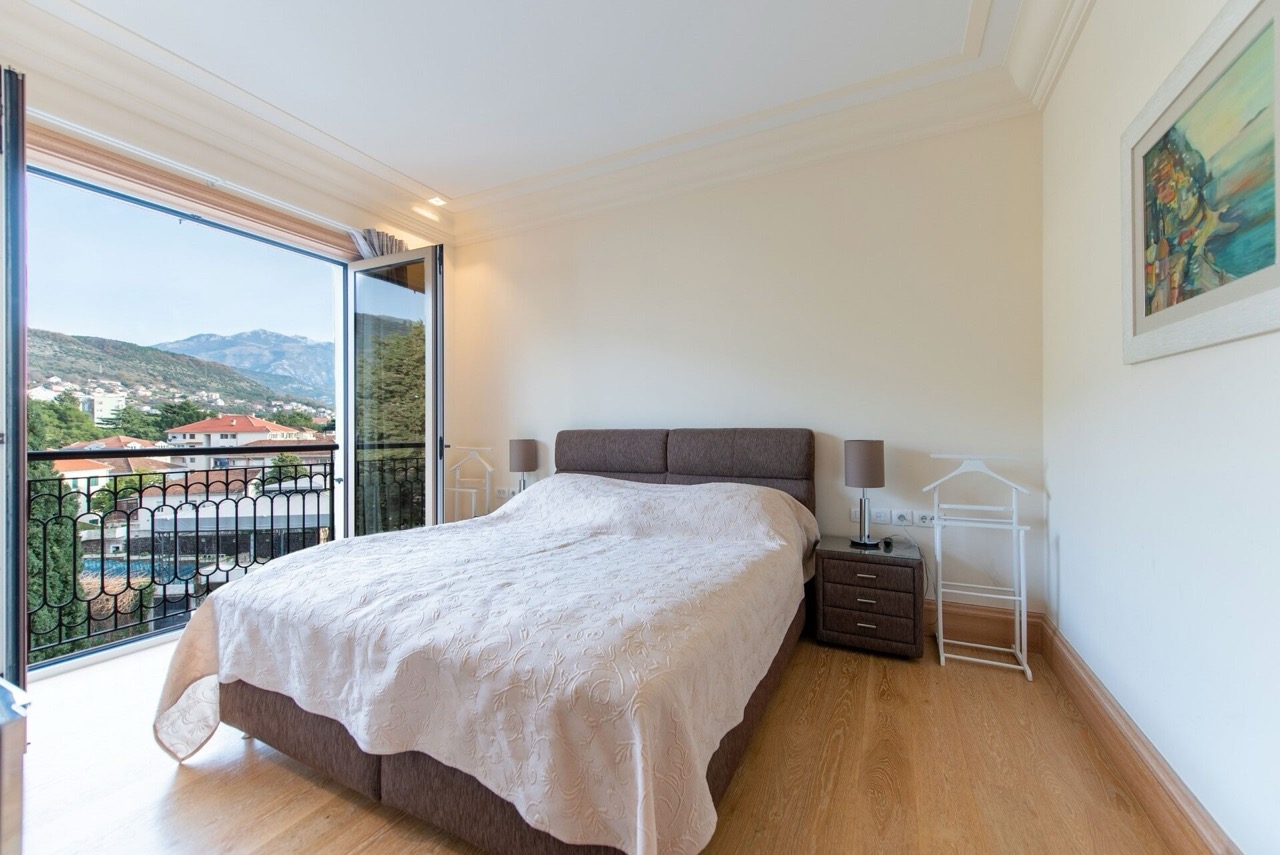 Bedroom in an apartment in Porto Montenegro, Tivat, Montenegro: double bed, balcony with mountain and city views.