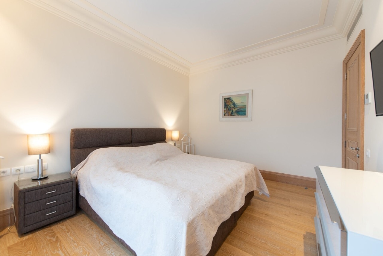Bright bedroom with a double bed in an apartment in Porto Montenegro, Tivat, Montenegro: modern interior.