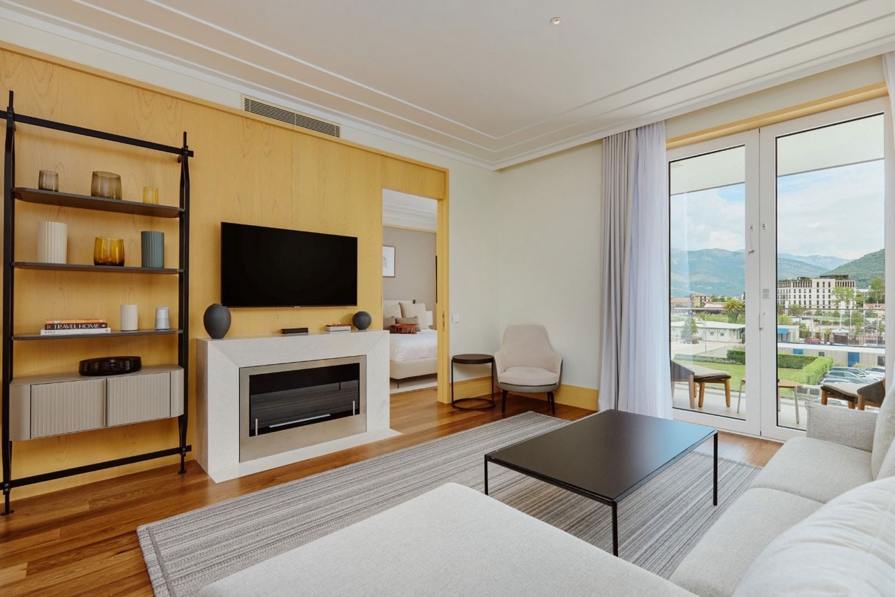 Living room in an apartment in Porto Montenegro, Tivat, Montenegro: modern interior with a fireplace, terrace, and mountain view.