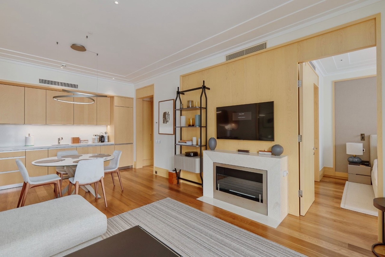 Living room with fireplace and kitchen in an apartment in Porto Montenegro, Tivat, Montenegro: modern interior, light wood.