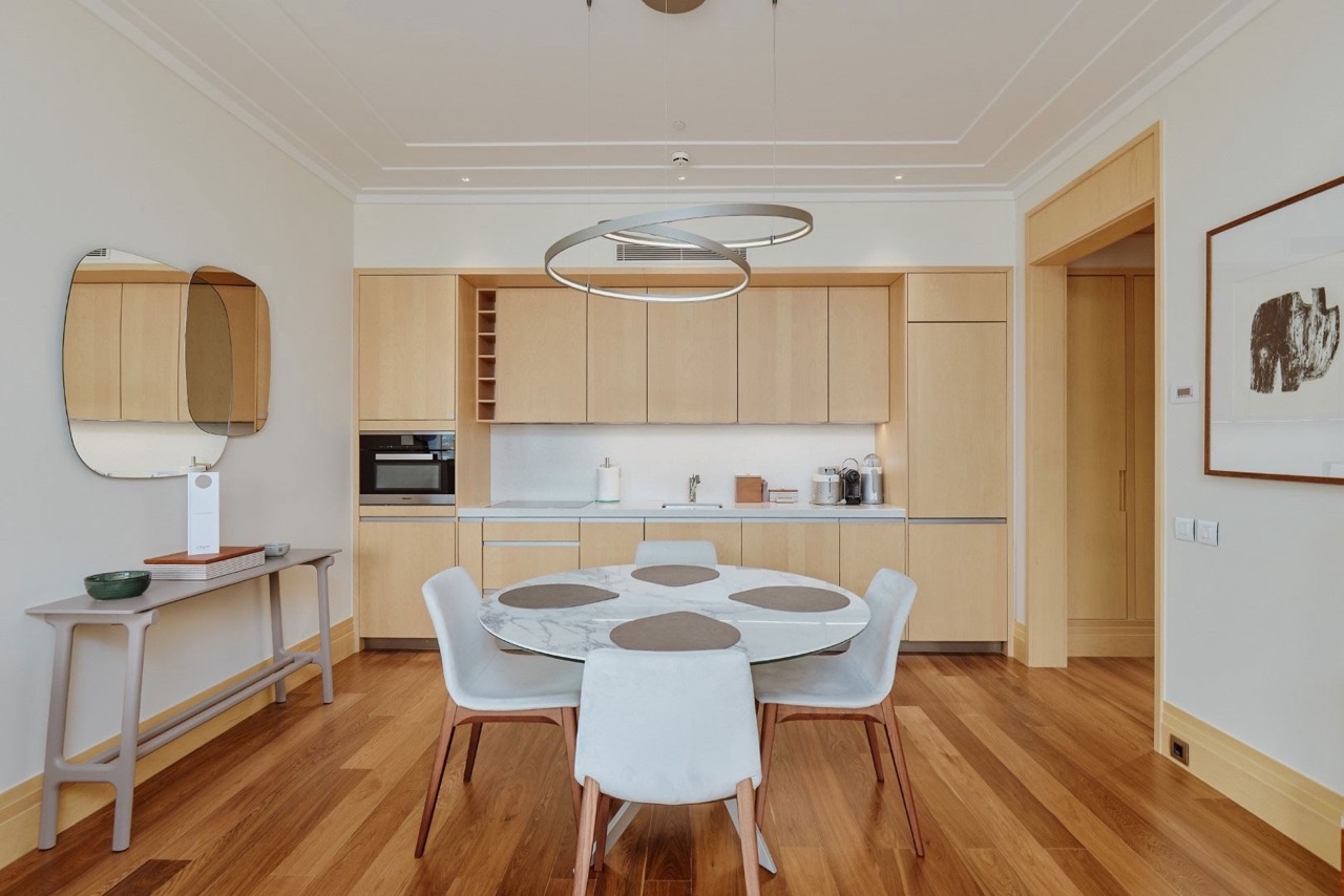 Modern kitchen in an apartment in Porto Montenegro, Tivat, Montenegro: light-colored furniture, marble table, and stylish interior.