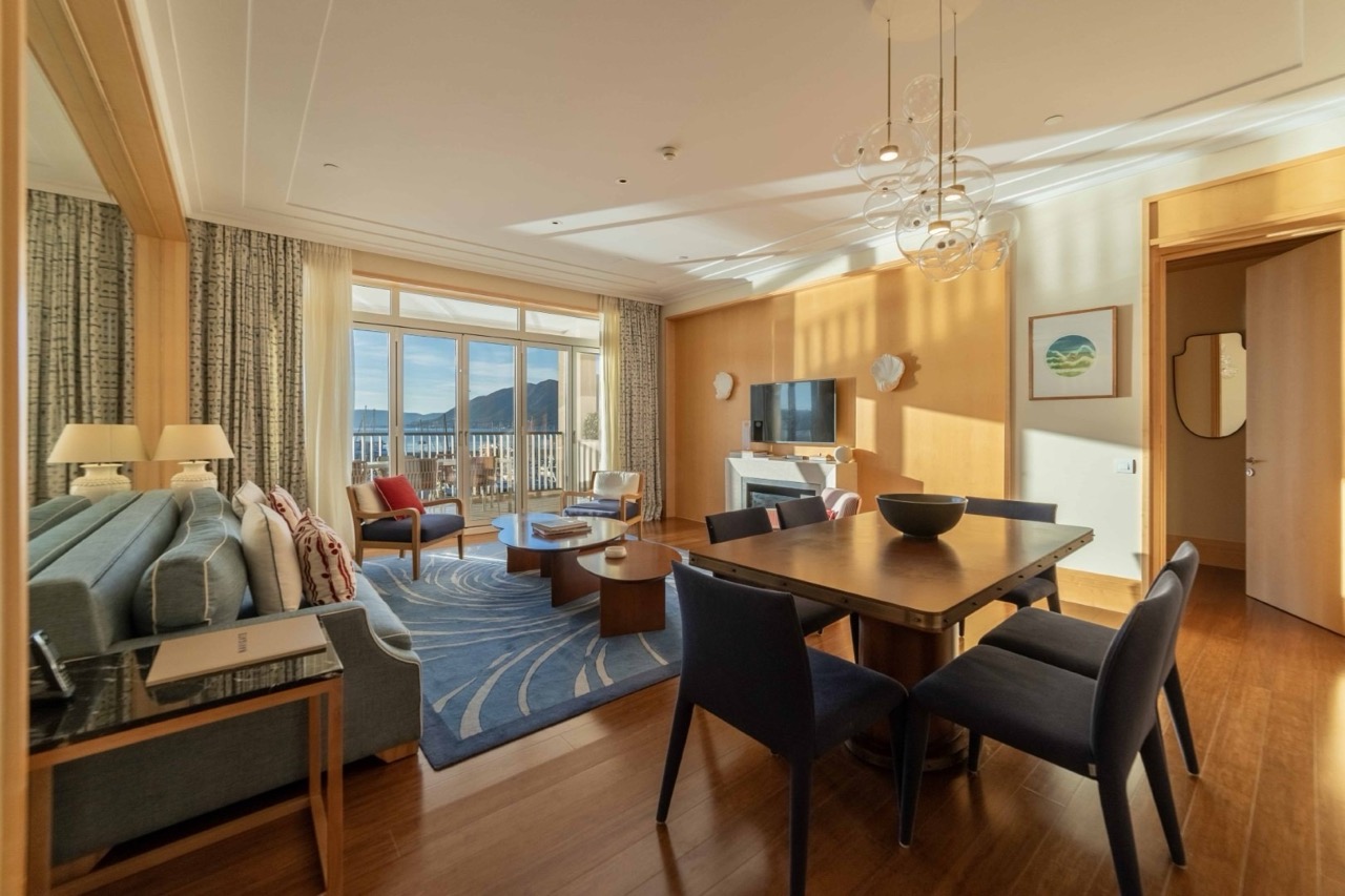 Living room with sea view in Porto Montenegro apartments, Tivat, Montenegro: stylish furniture, fireplace, and terrace.