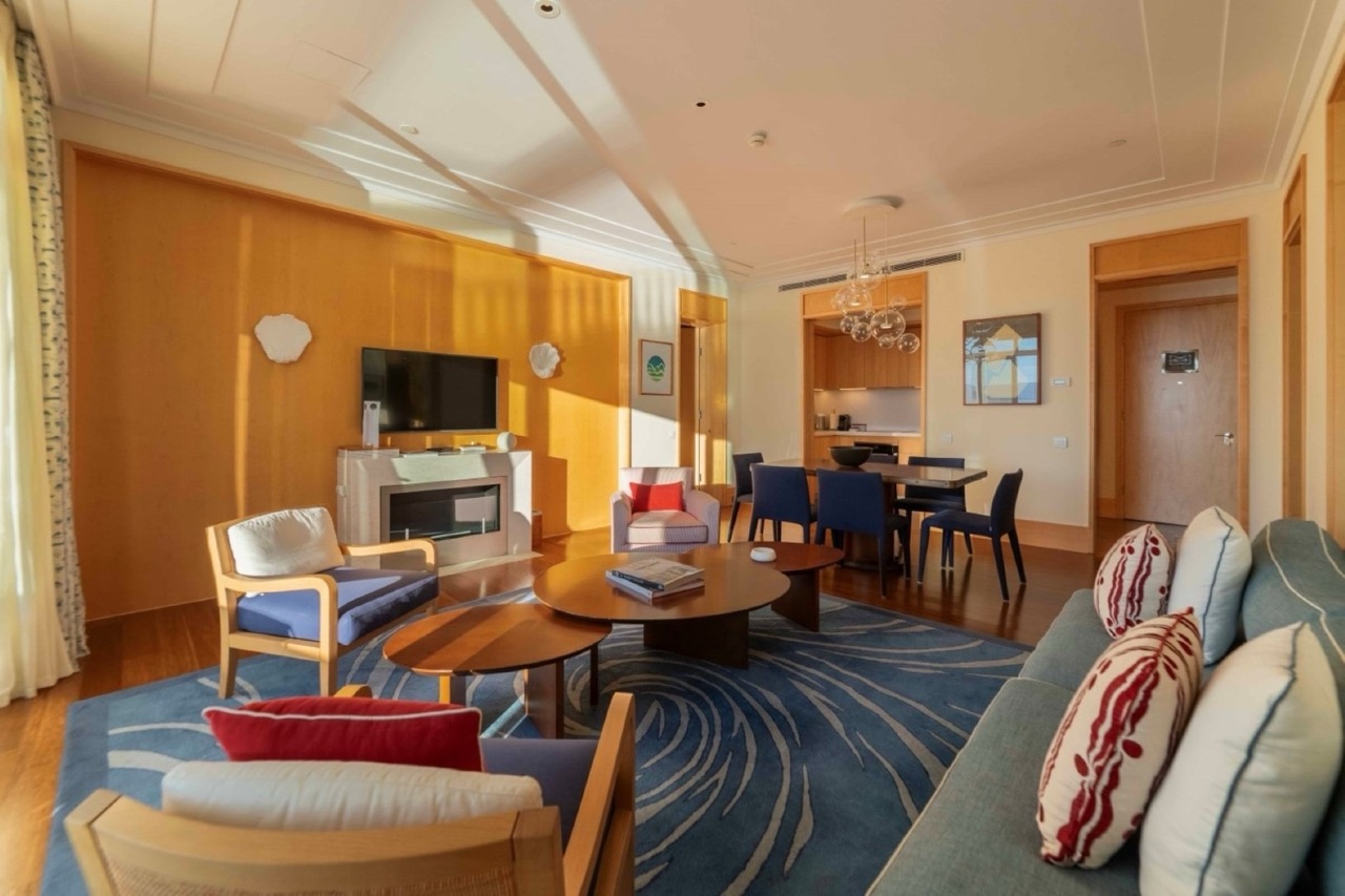 Living room with fireplace and dining area in an apartment in Porto Montenegro, Tivat, Montenegro: modern interior with furniture.