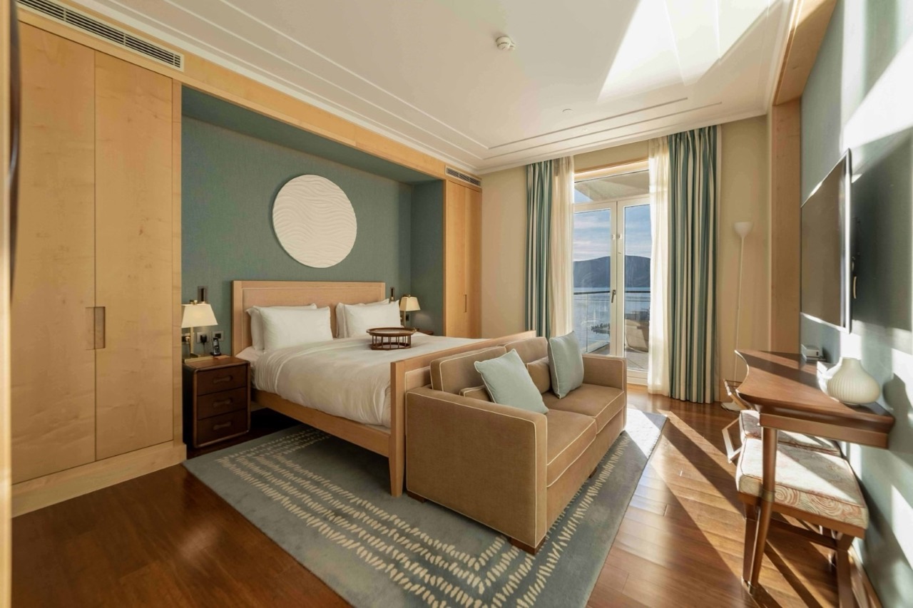 Bedroom in an apartment in Porto Montenegro, Tivat, Montenegro: double bed, sofa, and sea view from the terrace.