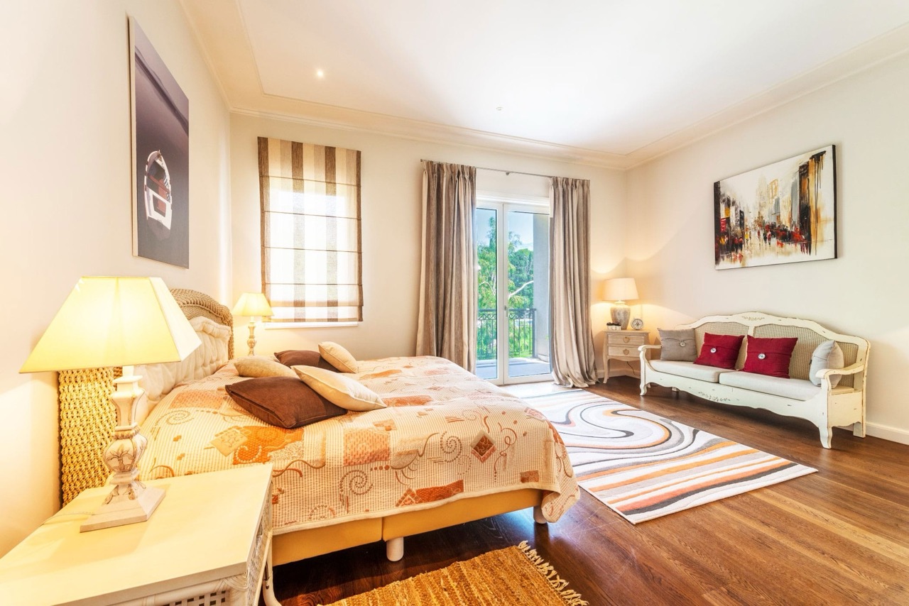 Bright bedroom with a double bed and sofa in an apartment in Porto Montenegro, Tivat, Montenegro, with access to the balcony.