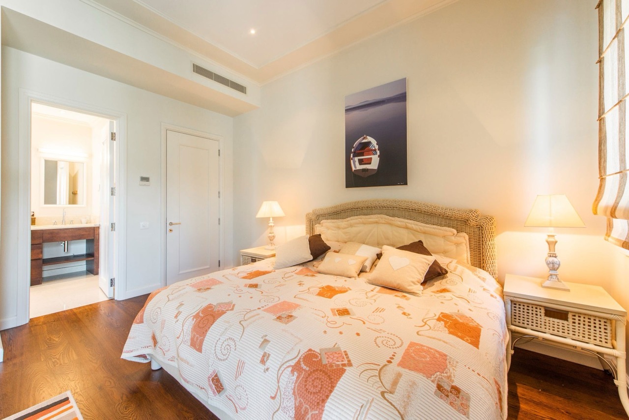 Cozy bedroom with wicker furniture in an apartment at Porto Montenegro, Tivat, Montenegro: view of the interior and bathroom.