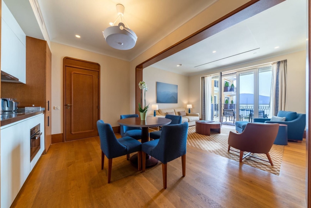 Living room with kitchen in Porto Montenegro apartments, Tivat, Montenegro: modern furniture, sea and terrace view.