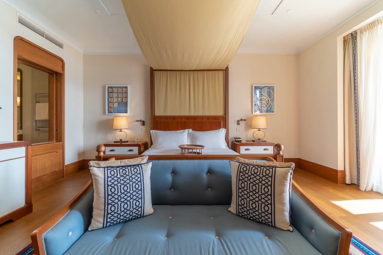 Luxurious bedroom with a double bed and a blue sofa in the Porto Montenegro apartments, Tivat, Montenegro.