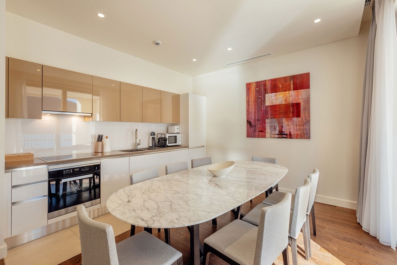 Modern kitchen with a marble table in an apartment in Portonovi, Kumbor, Montenegro: glossy cabinets and stylish decor.