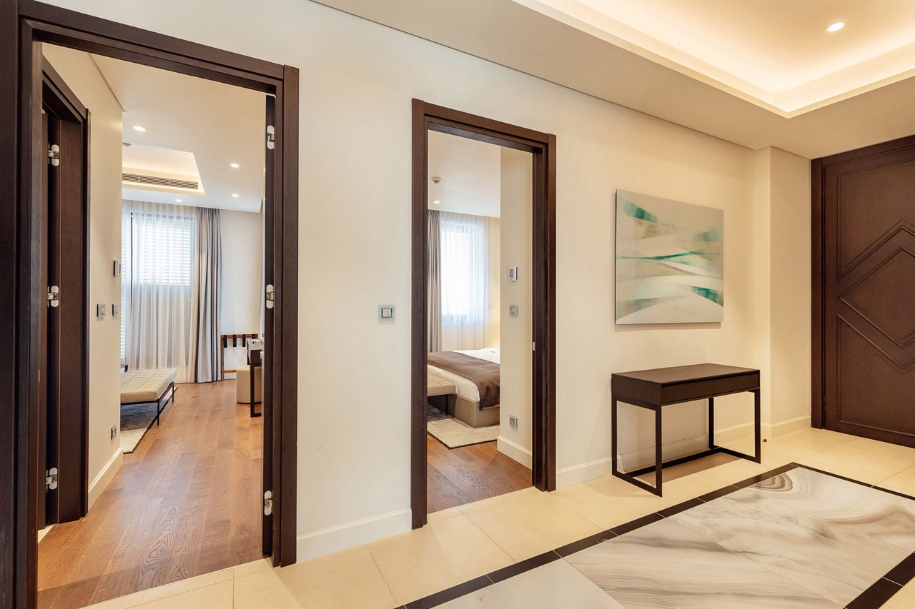 Modern hallway interior with two bedrooms in Portonovi apartments, Kumbor, Montenegro: marble floor and decor.