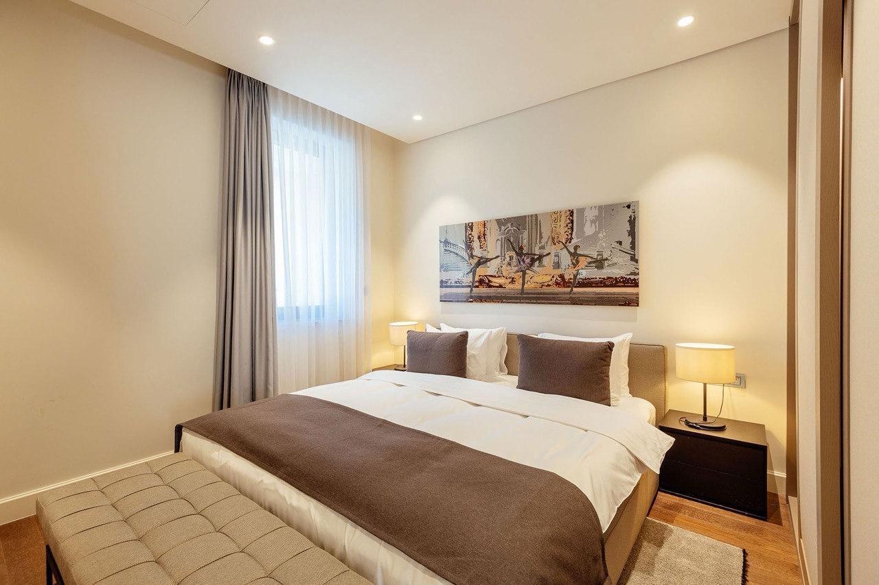 Modern bedroom in an apartment in Portonovi, Kumbor, Montenegro: double bed, upholstered bench, and stylish decor.