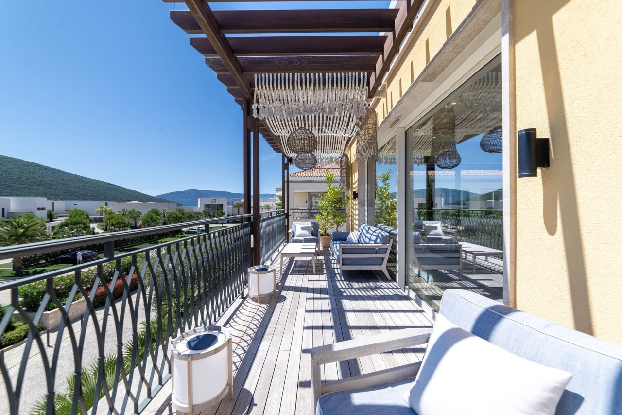 Spacious terrace with wooden decking and furniture in the Portonovi residential complex, Kumbor, Montenegro.