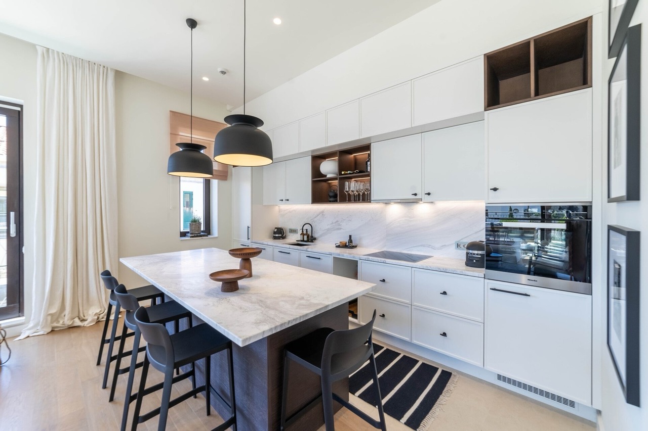Modern kitchen with an island in an apartment in Portonovi, Kumbor, Montenegro: white cabinetry, marble countertop, and appliances.