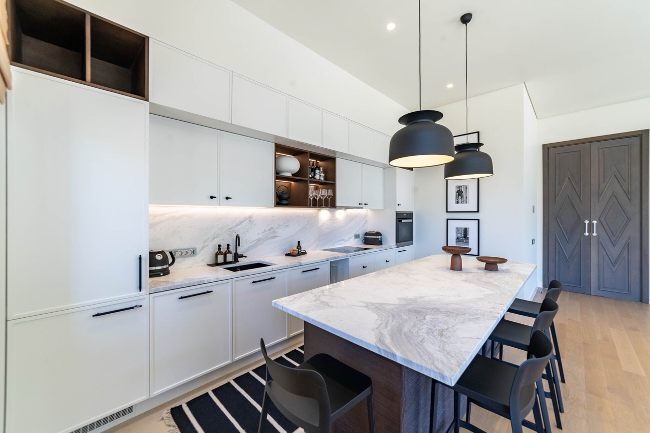 Modern kitchen with a marble island in an apartment in Portonovi, Kumbor, Montenegro: white cabinetry and stylish decor.