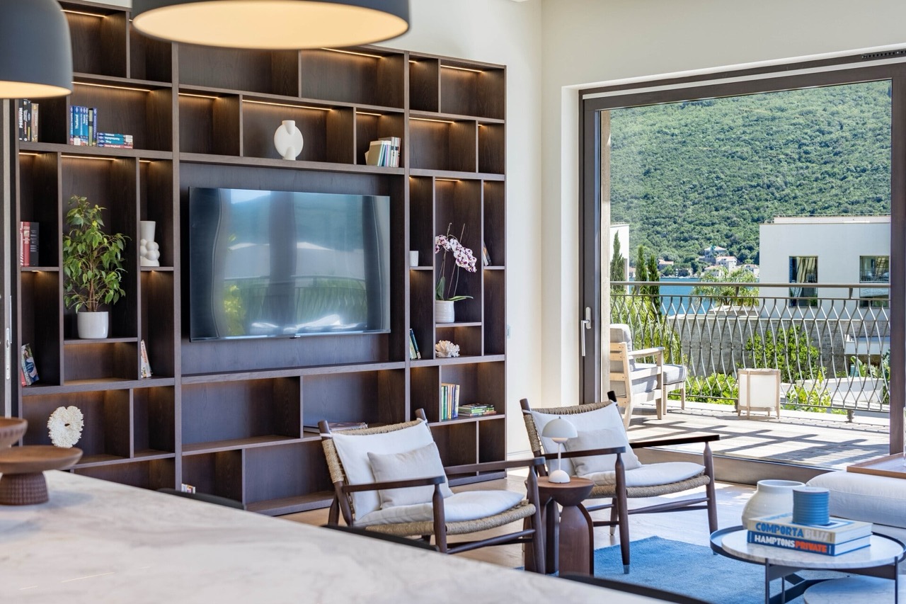 Living room in an apartment in Portonovi, Kumbor, Montenegro: modern shelving, sea and mountain views from the terrace.