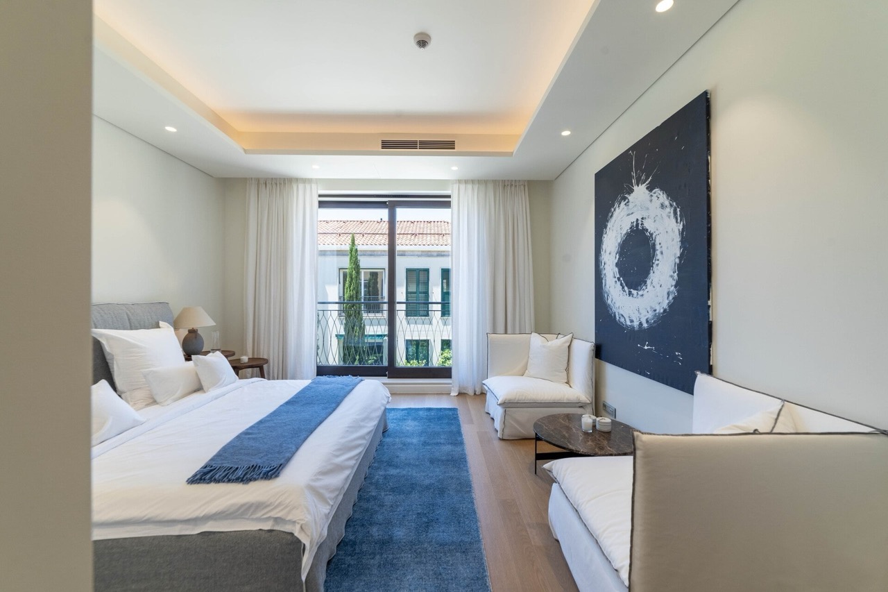 Modern bedroom in Portonovi, Kumbor, Montenegro: double bed, seating area, balcony, and stylish interior.