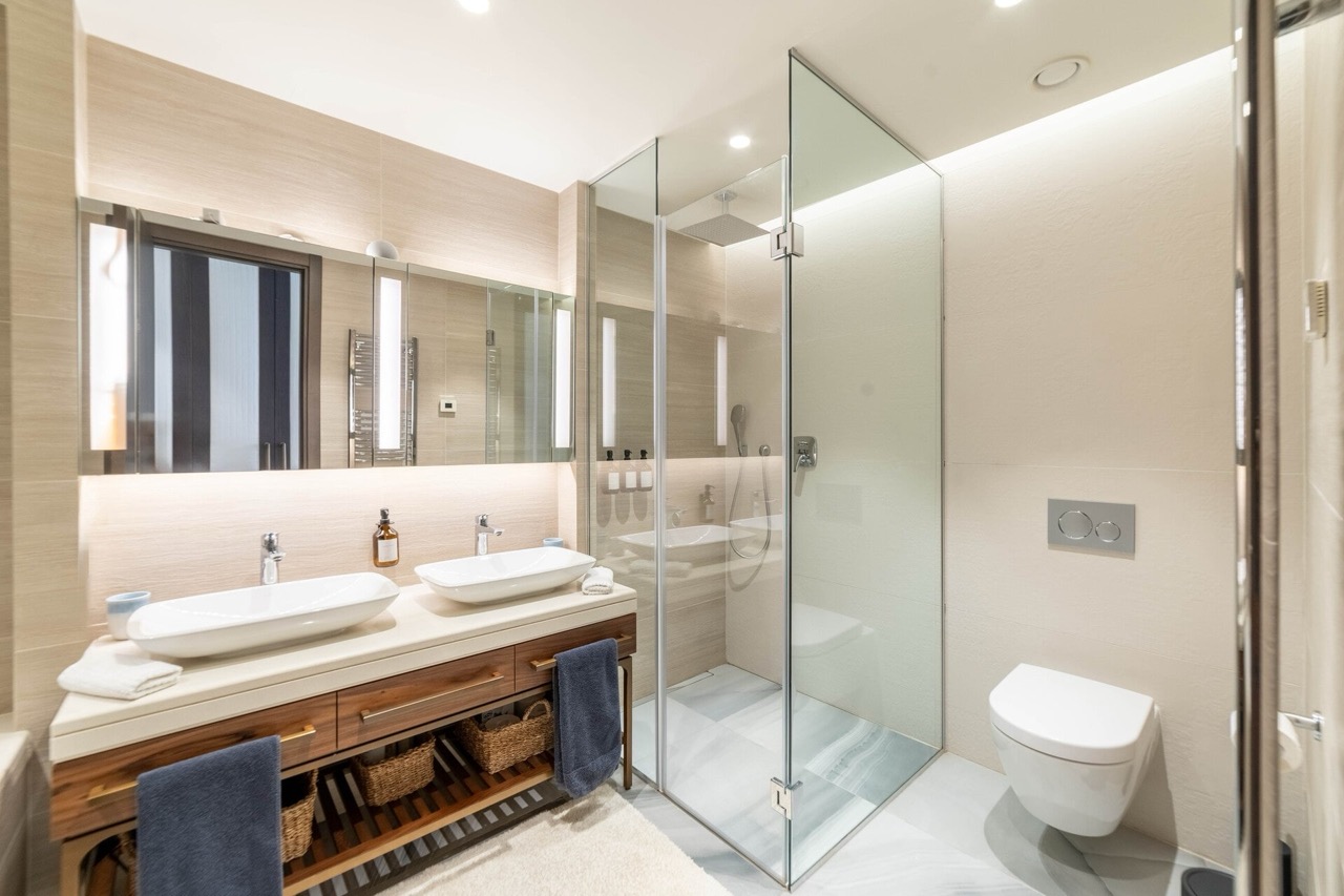 Modern bathroom with two sinks and a shower cabin in an apartment in Portonovi, Kumbor, Montenegro.
