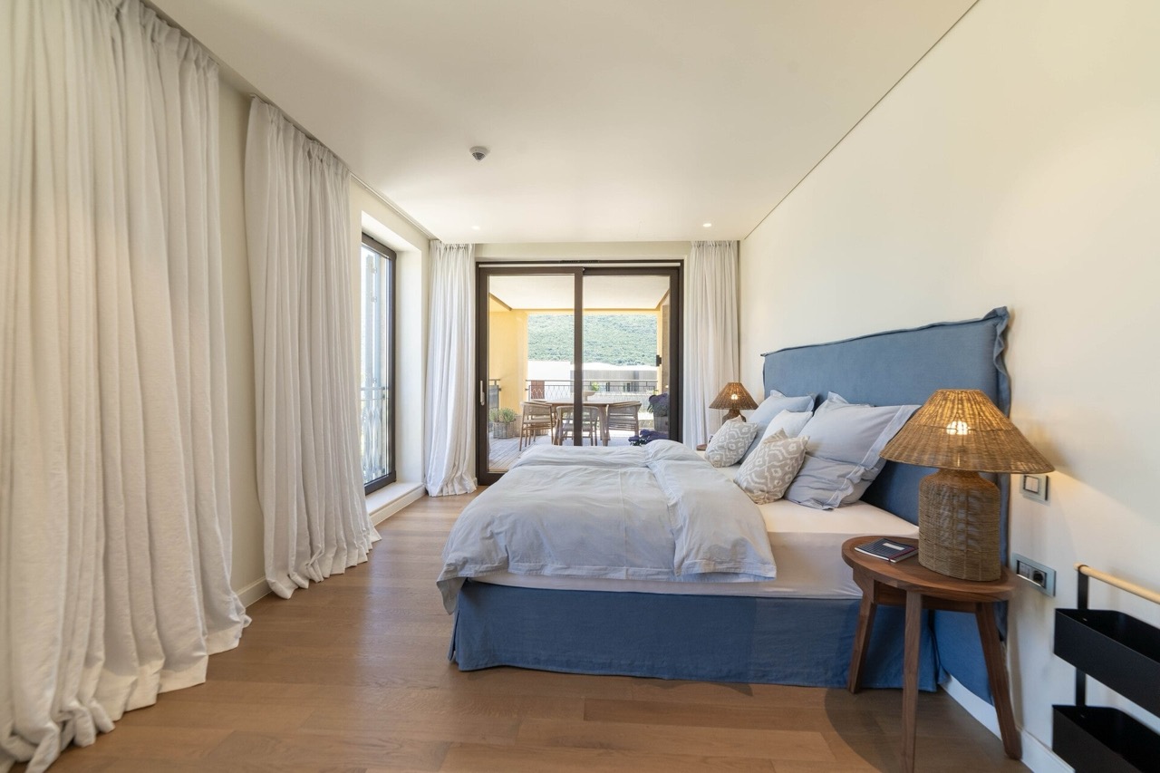 Cozy bedroom with a double bed and access to the terrace in the Portonovi apartments, Kumbor, Montenegro.