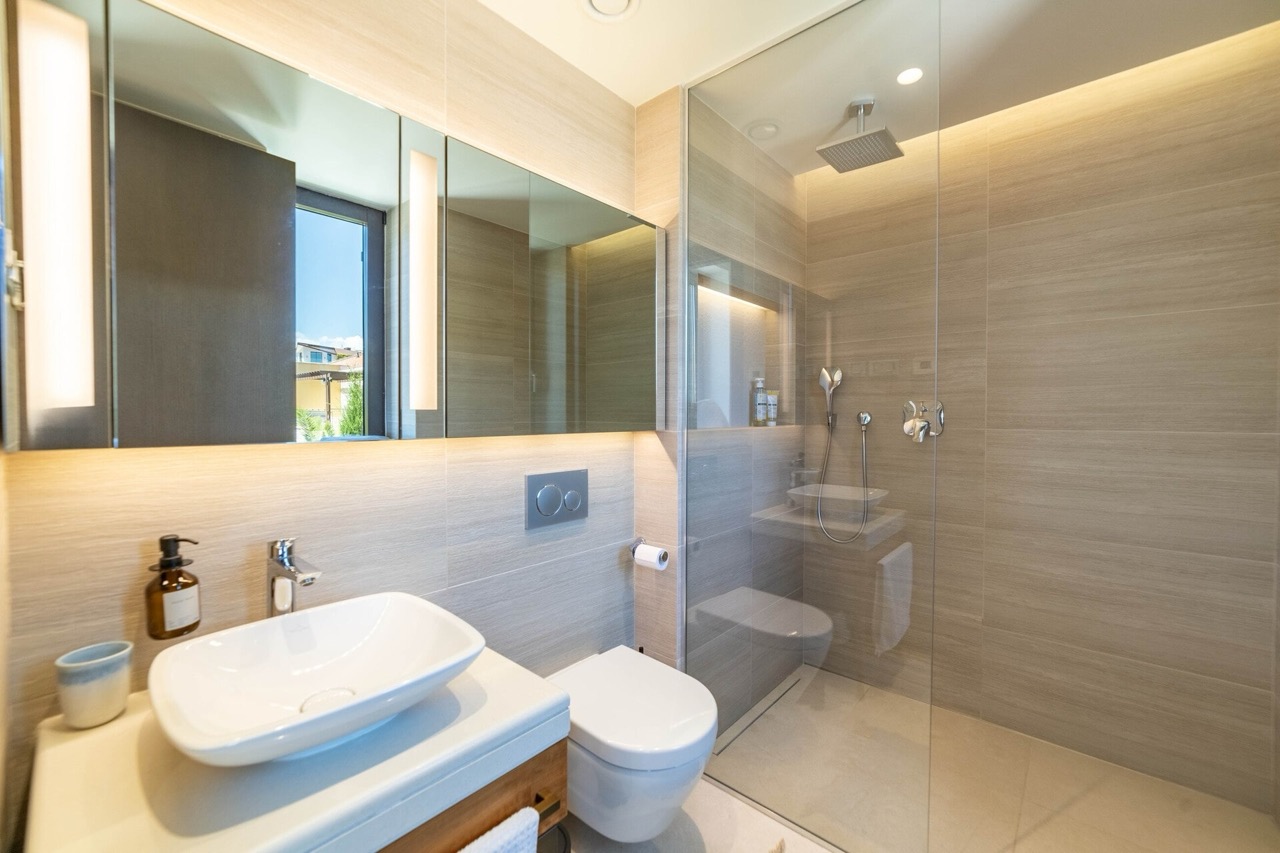 Modern bathroom in an apartment in Portonovi, Kumbor, Montenegro: shower cabin, countertop sink, and lighting.