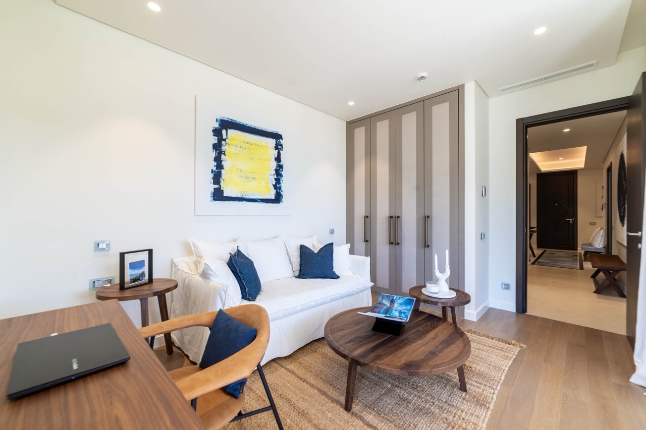 Modern living room with a white sofa and wooden furniture in an apartment in the Portonovi complex, Kumbor, Montenegro.