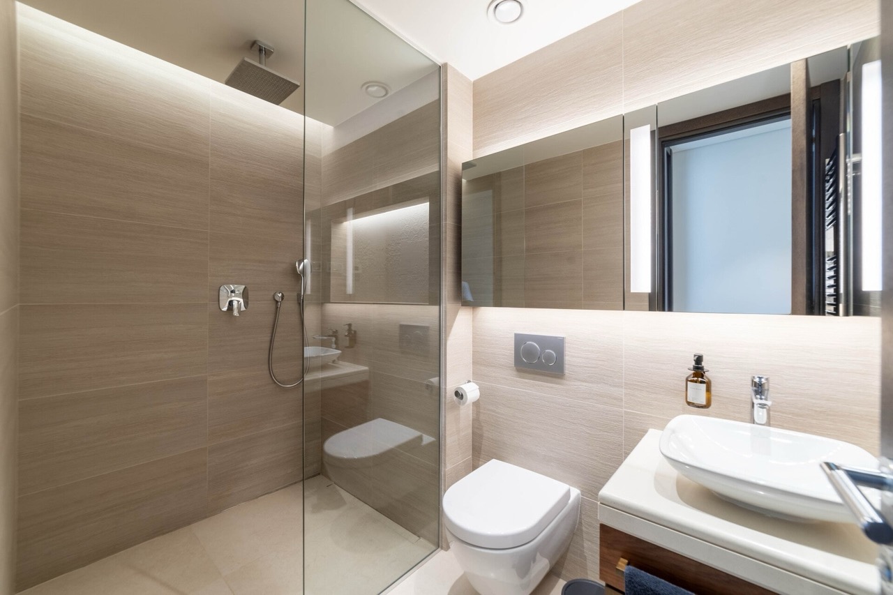 Modern bathroom in an apartment in Portonovi, Kumbor, Montenegro: shower cabin, wall-mounted toilet, and stylish sink.