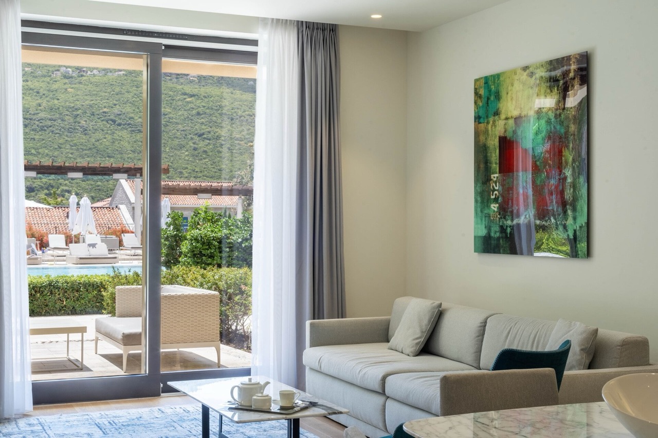 Living room with panoramic view of the pool in Portonovi apartments, Kumbor, Montenegro: modern interior with a sofa.