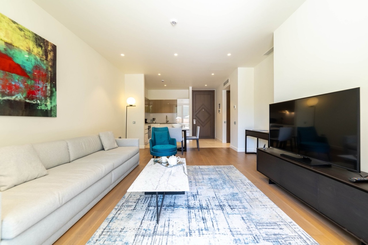 Modern living room in an apartment in Portonovi, Kumbor, Montenegro: light sofa, marble coffee table, and TV area.