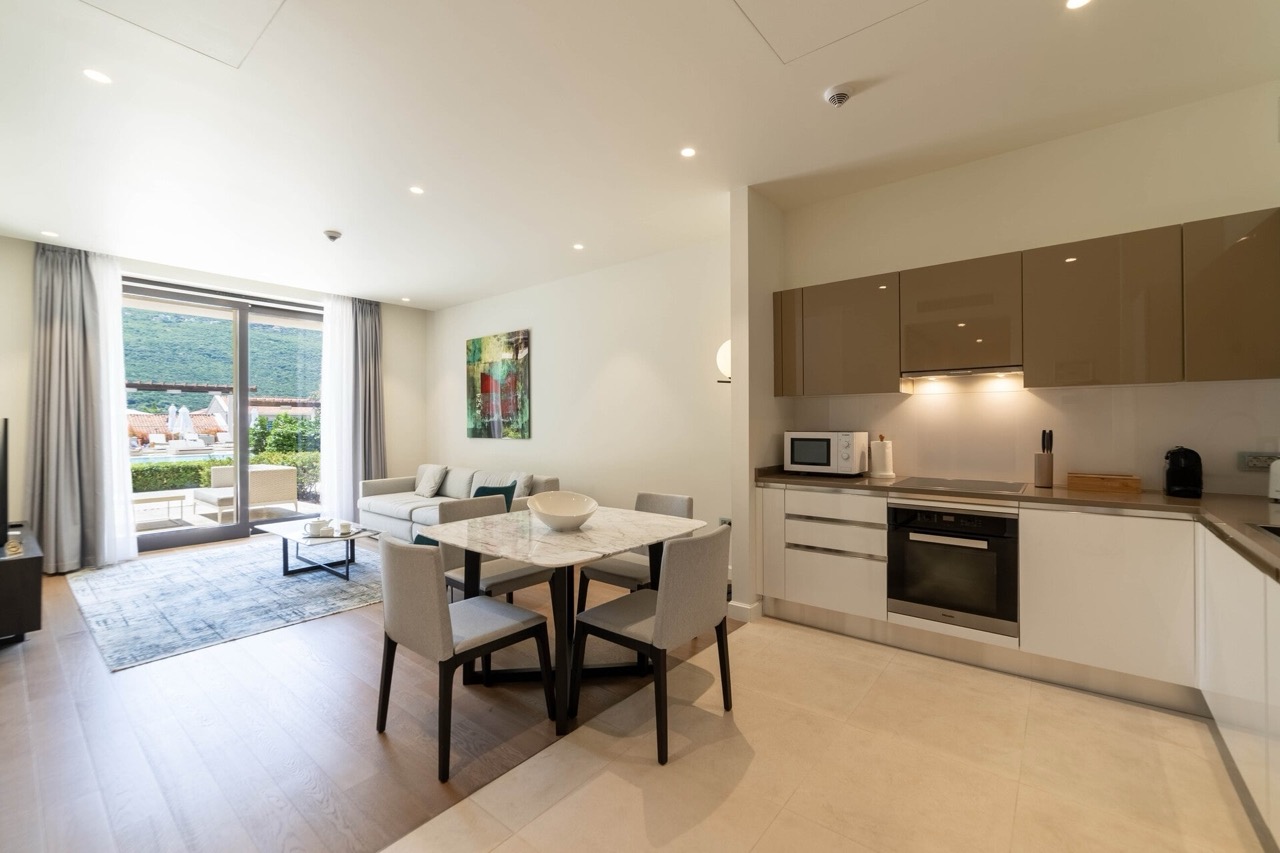 Modern living room with kitchen in Portonovi apartments, Kumbor, Montenegro: bright interior, terrace with a view.