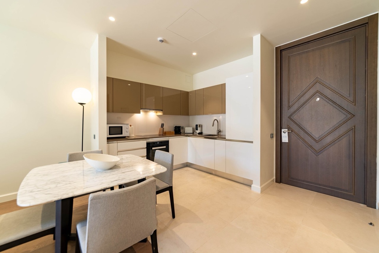 Modern kitchen-dining room in an apartment in Portonovi, Kumbor, Montenegro: glossy cabinetry and a marble dining table.