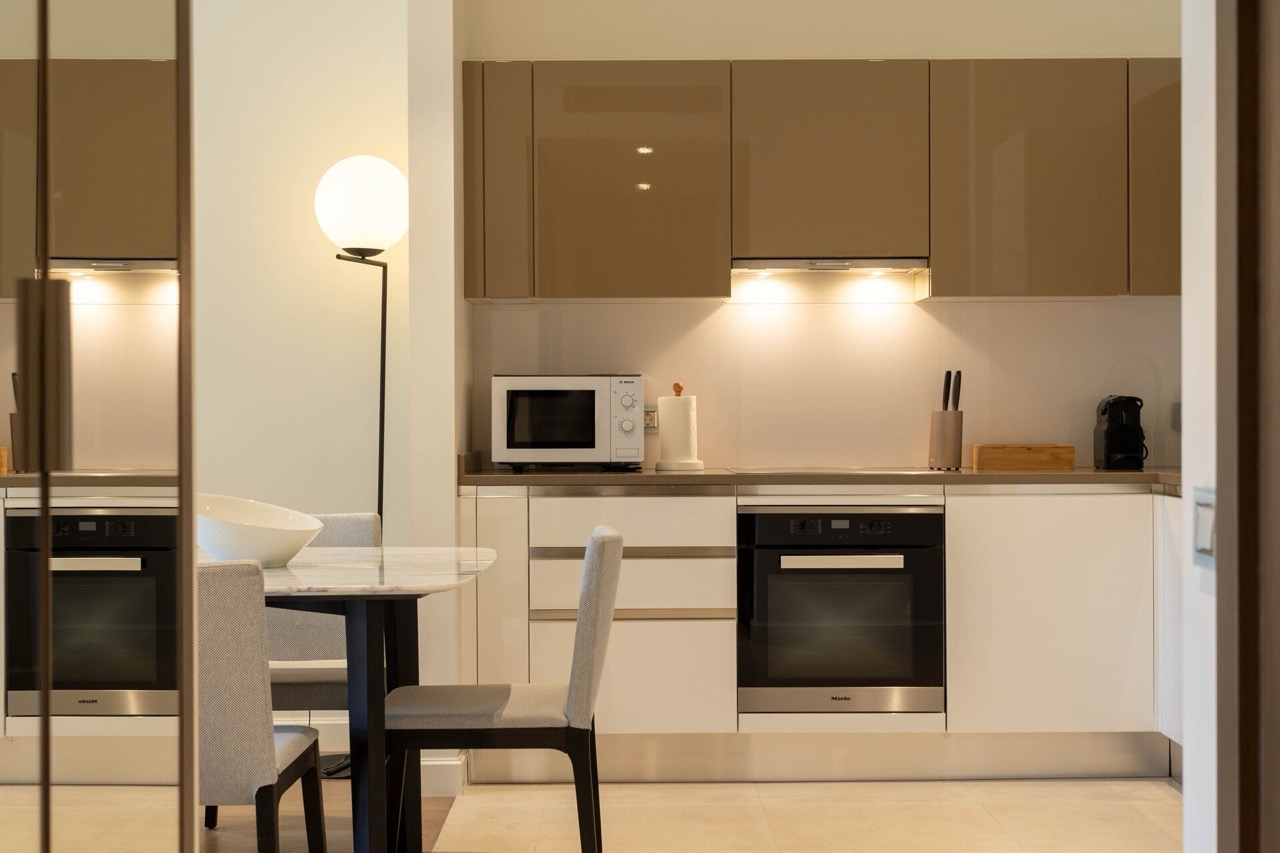 Modern kitchen in an apartment in Portonovi, Kumbor, Montenegro: glossy fronts, Miele appliances, and a dining area.
