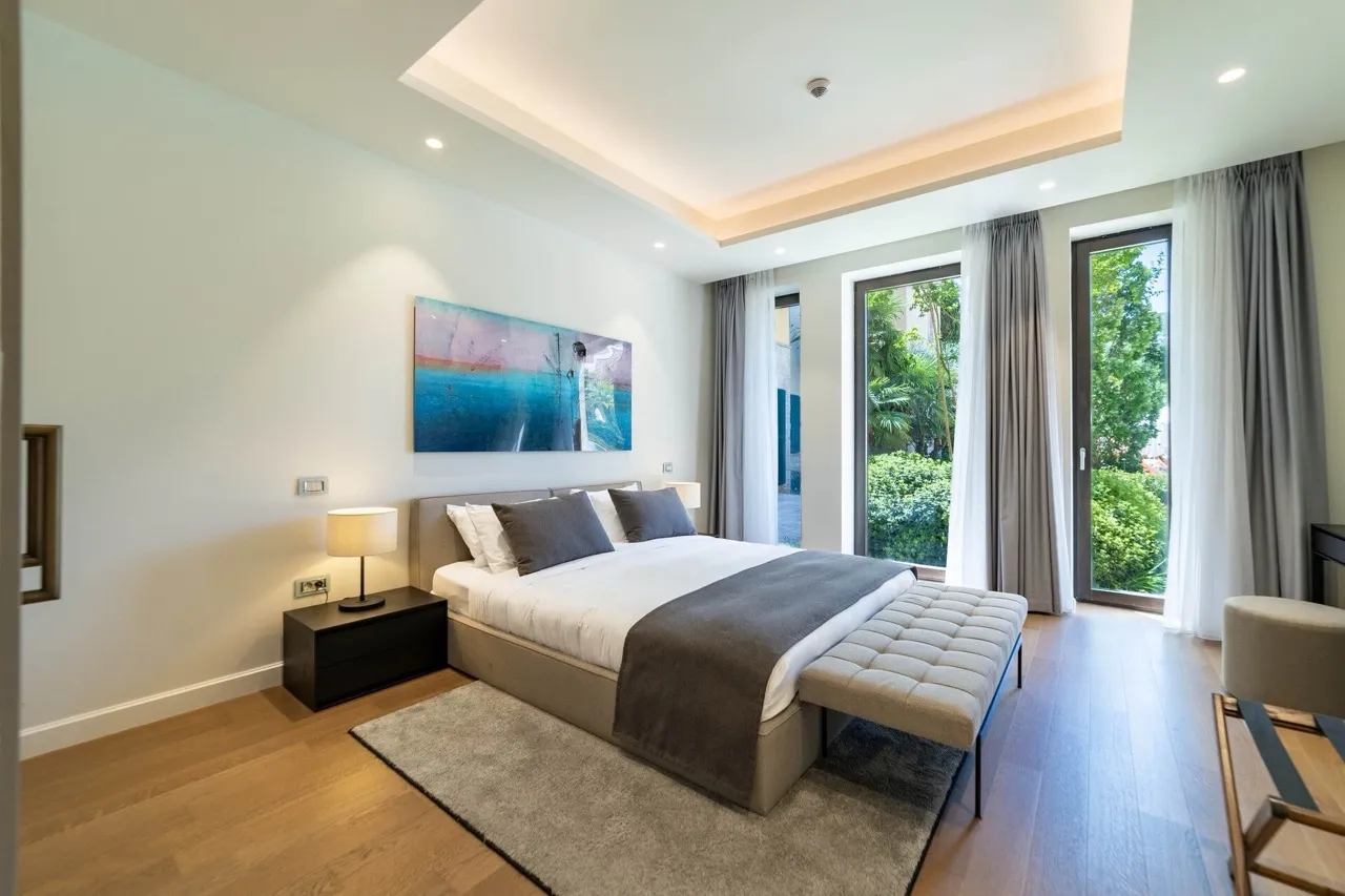 Modern bedroom featuring a double bed, nightstand, rug, and abstract wall art.