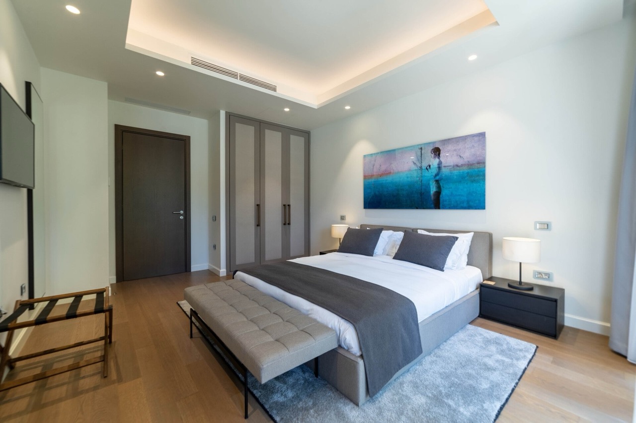 Modern bedroom with a double bed in an apartment in Portonovi, Kumbor, Montenegro: stylish interior and parquet flooring.