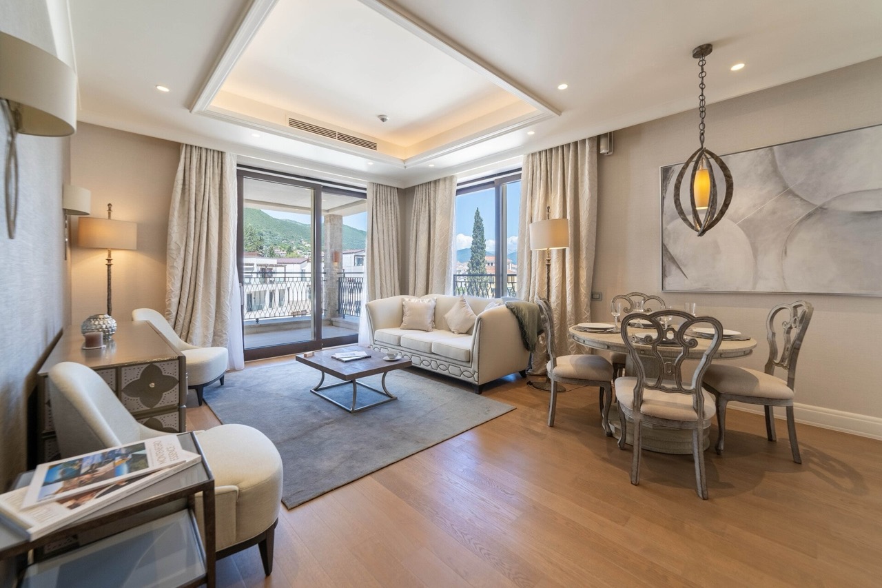 Bright living room with dining area in Portonovi apartments, Kumbor, Montenegro: modern furniture and mountain view.