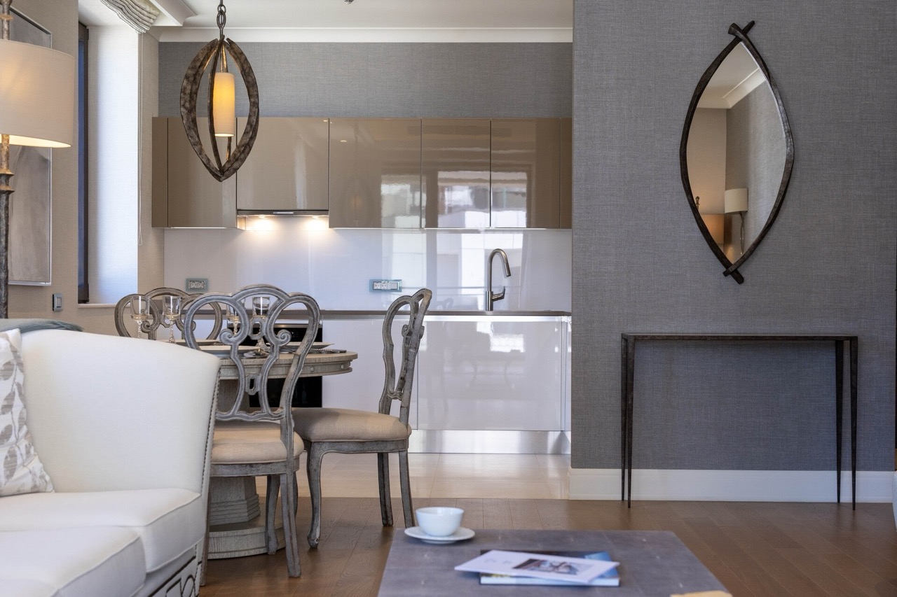 Modern living room with kitchen in an apartment in Portonovi, Kumbor, Montenegro: stylish furniture, gray wallpaper, and designer decor.