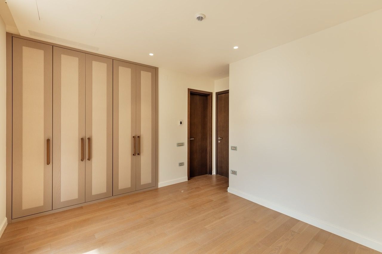 Bedroom with a modern wardrobe and parquet flooring in a villa in Portonovi, Kumbor, Montenegro. Interior with high-quality finishes.