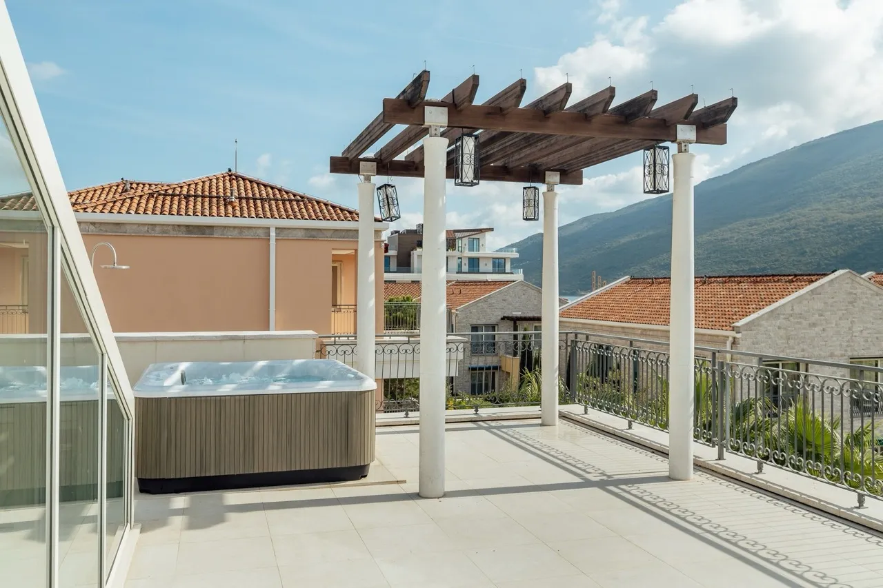 Open terrace featuring a hot tub, wooden pergola with lanterns, and mountain views.
