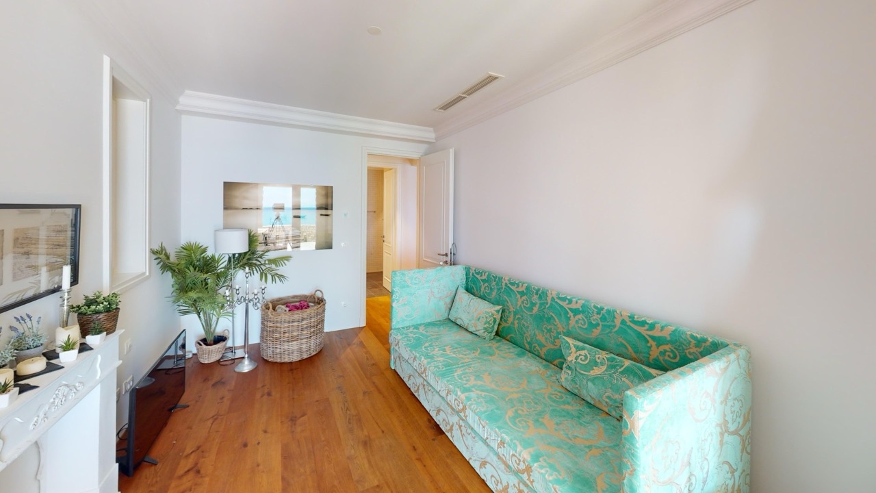 Гостиная с бирюзовым диваном и видом на море в апартаментах Lustica Bay, Радовичи, Черногория.
