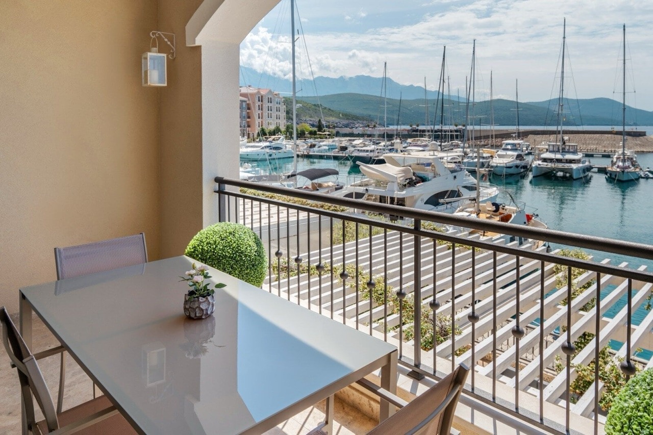 Balcony with dining area and a view of the yacht marina in Luštica Bay, Radovići, Montenegro.