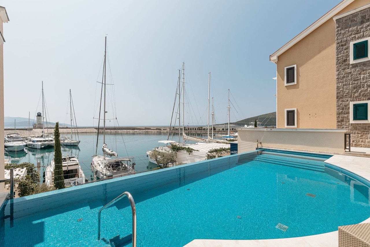 Infinity pool overlooking the marina and yachts in the upscale Luštica Bay complex, Radovići, Montenegro.