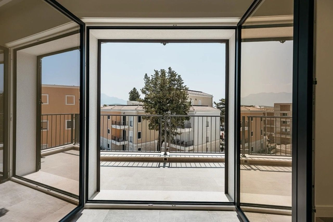 View from the spacious terrace of an apartment in Luštica Bay, Radovići, Montenegro: panoramic windows and modern architecture.