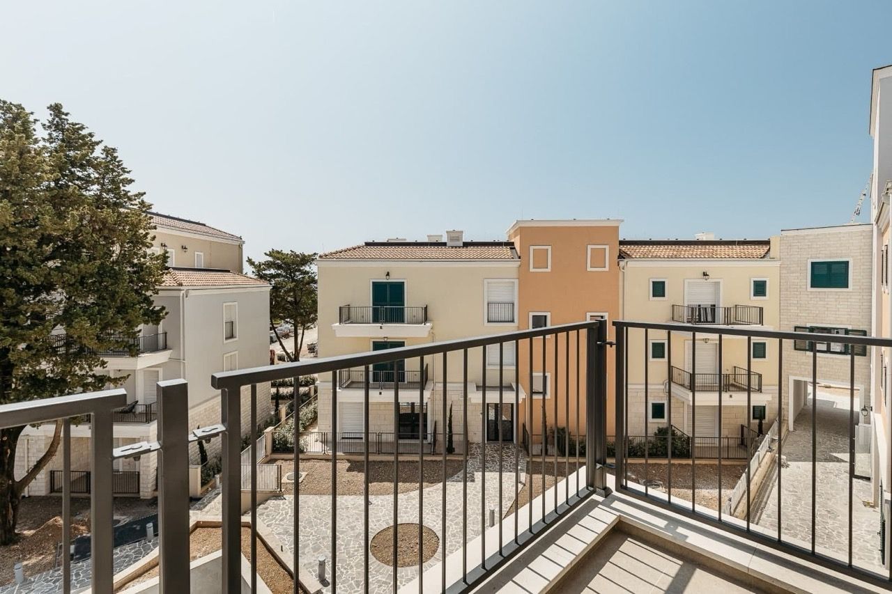 View from the balcony of a modern residential complex in Luštica Bay, Radovići, Montenegro: light facades and well-kept grounds.