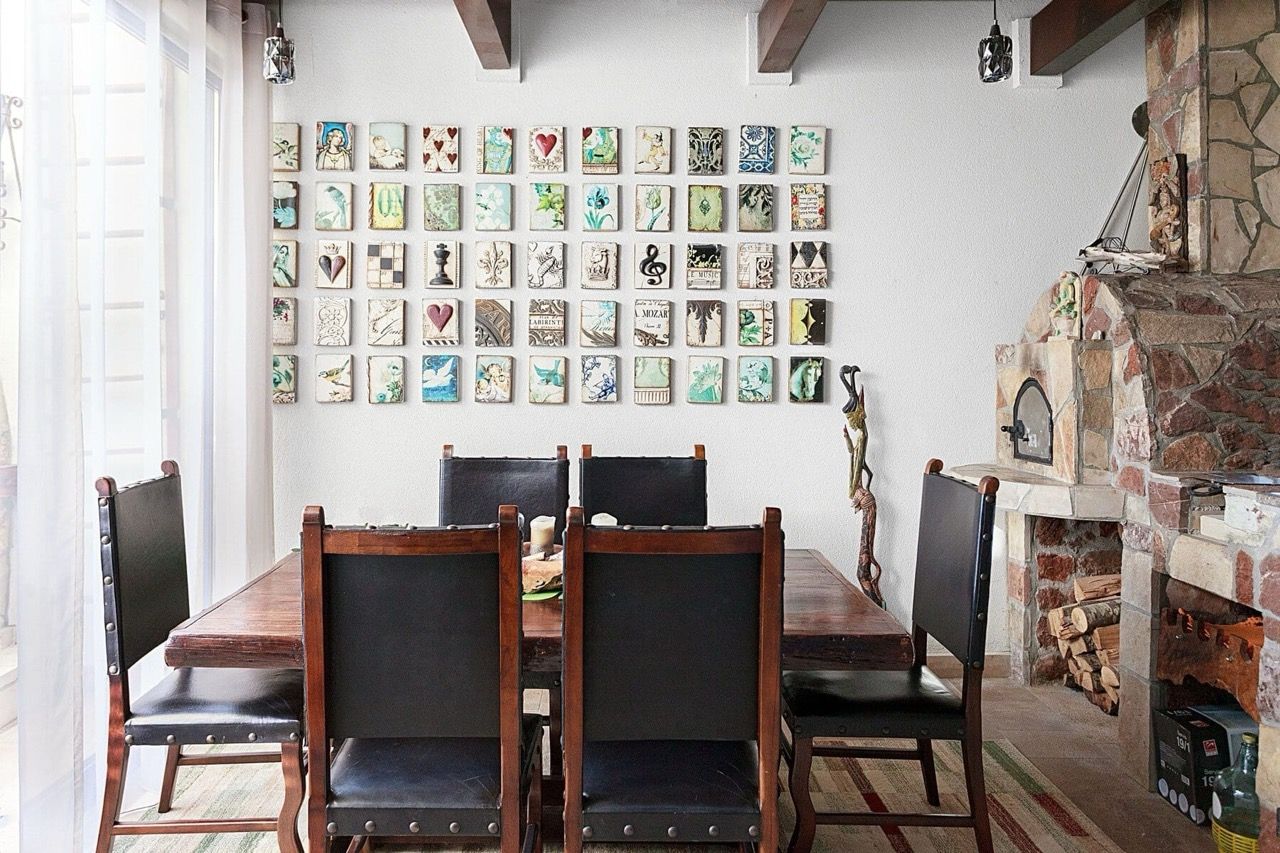 Villa living room in Luštica Bay, Radovići, Montenegro: dining area with a wooden table, fireplace, and wall decor.