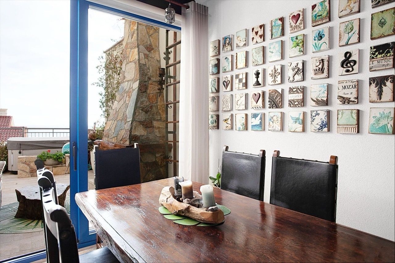 Living room with a wooden table and wall decor in a villa in Luštica Bay, Radovići, Montenegro, with access to the terrace.