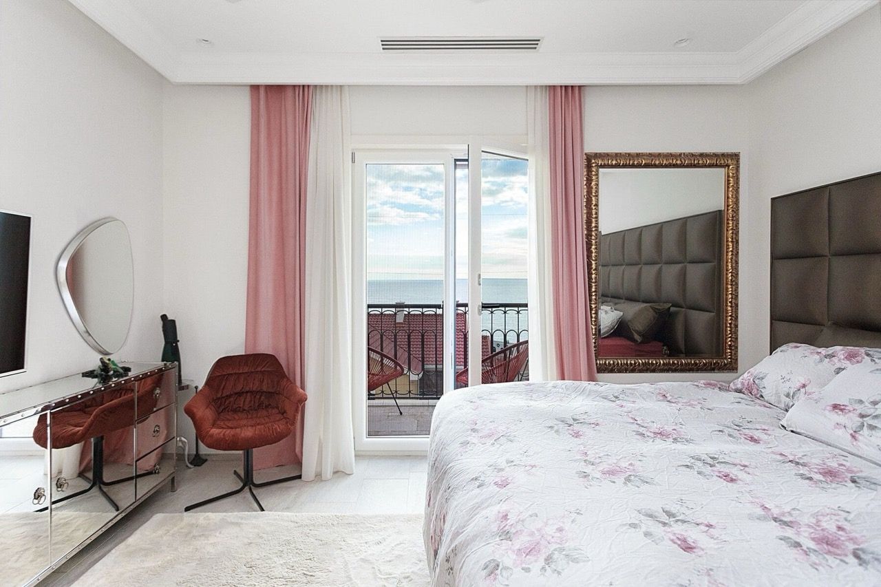 Bedroom with sea view in a villa in Luštica Bay, Radovići, Montenegro: double bed, mirrors, and terrace.