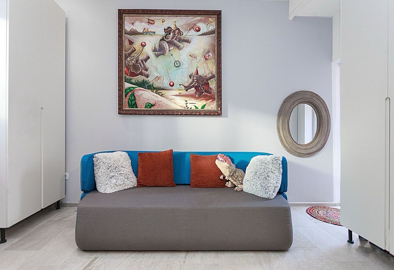 Modern living room with a blue sofa and a painting in a villa in Luštica Bay, Radovići, Montenegro.