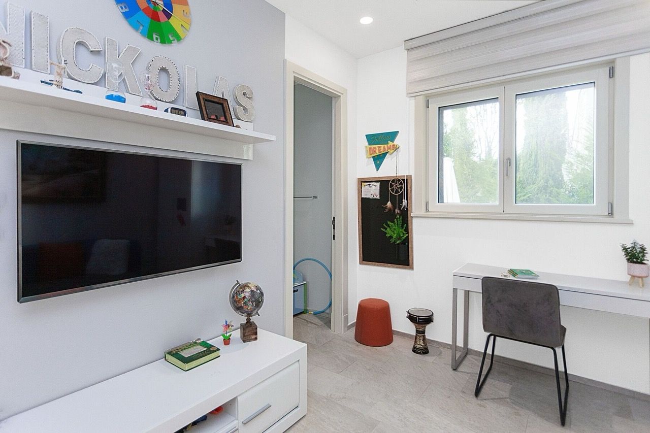 Children's room with a desk and TV in a villa in Luštica Bay, Radovići, Montenegro: modern interior with furniture.