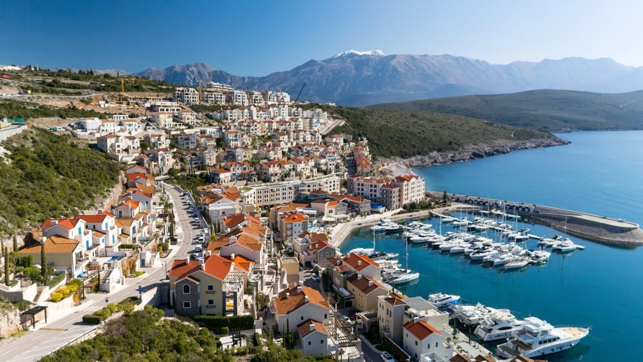 Aerial view of the Luštica Bay resort in Radovići, Montenegro: luxury villas, a yacht marina, and a seascape.